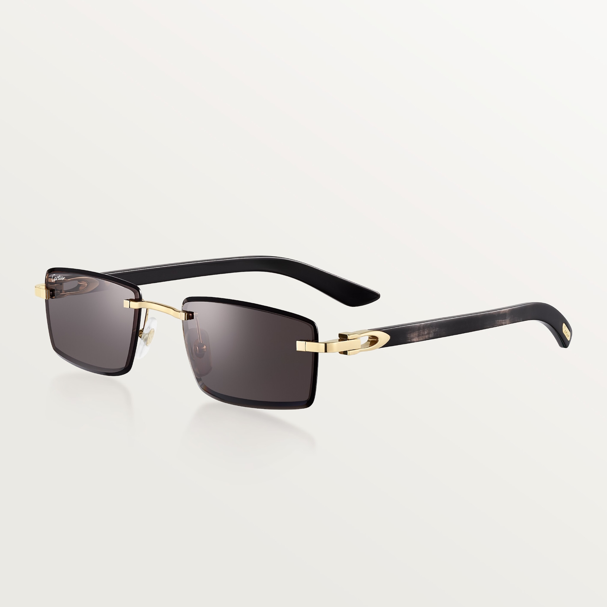 Sunglasses with Elongated C de Cartier motifSmooth golden-finish metal, black horn, grey lenses