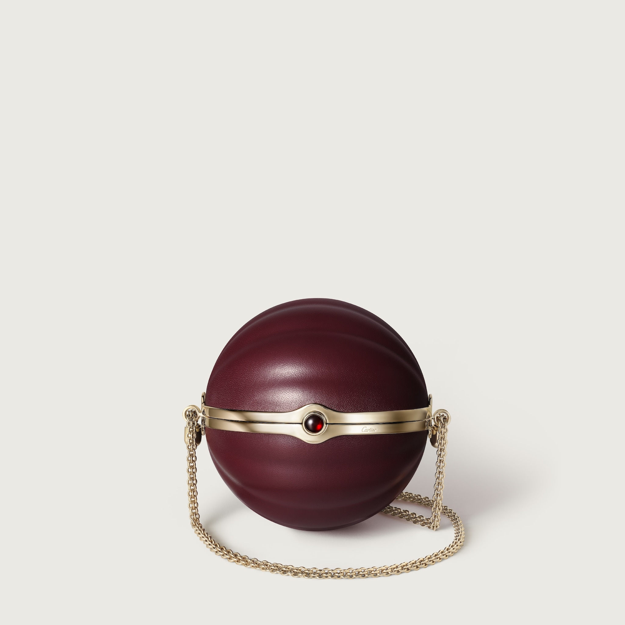 Round bag with gadroon motif, Cartier SoirBurgundy lambskin, hessonite garnet and golden finish