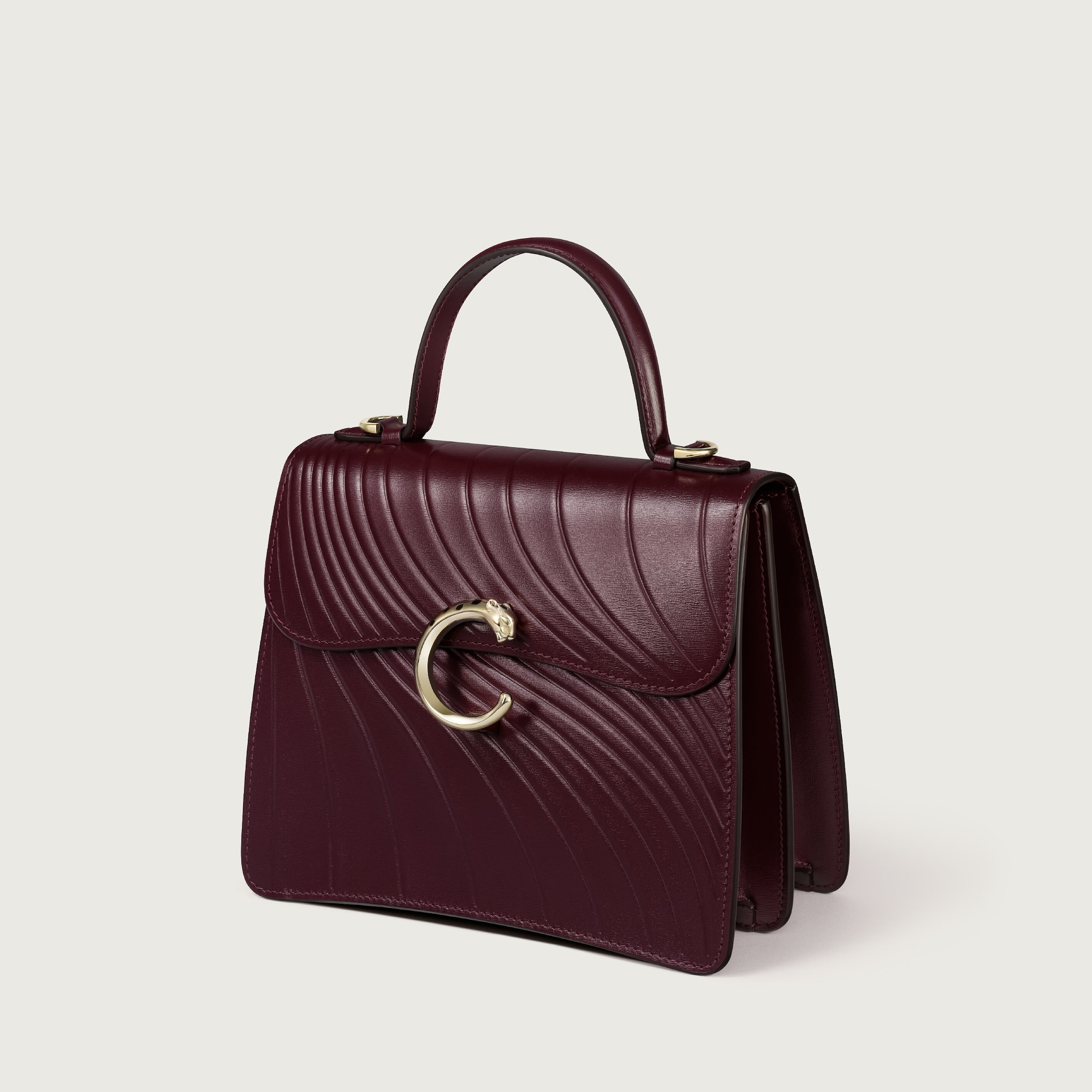 Small model handle bag, Panthère C de CartierGrape calfskin, embossed Cartier signature motif, golden finish